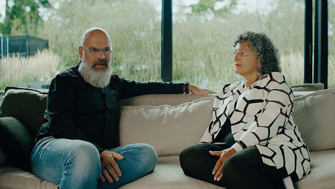 Christa und Lars Courage (Architekten) sitzen auf einer Couche