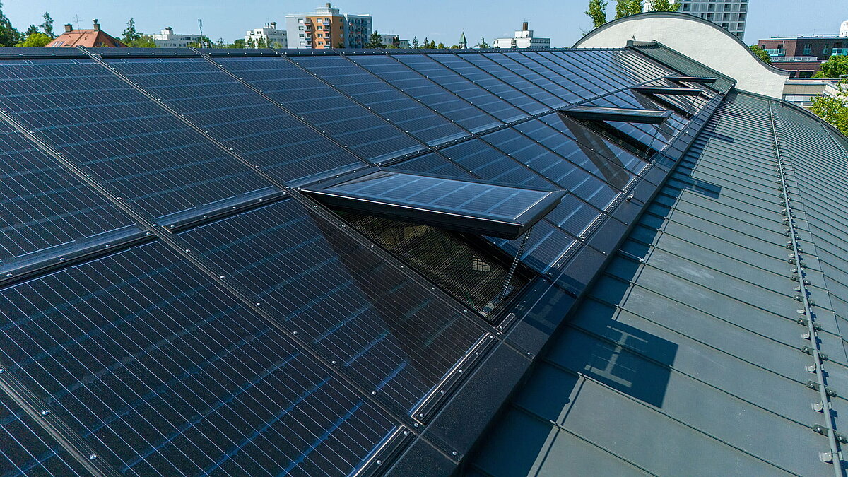 LAMILUX Glasdach PR60 mit integrierten PV-Glasfeldern und geöffneten Lüftungselementen