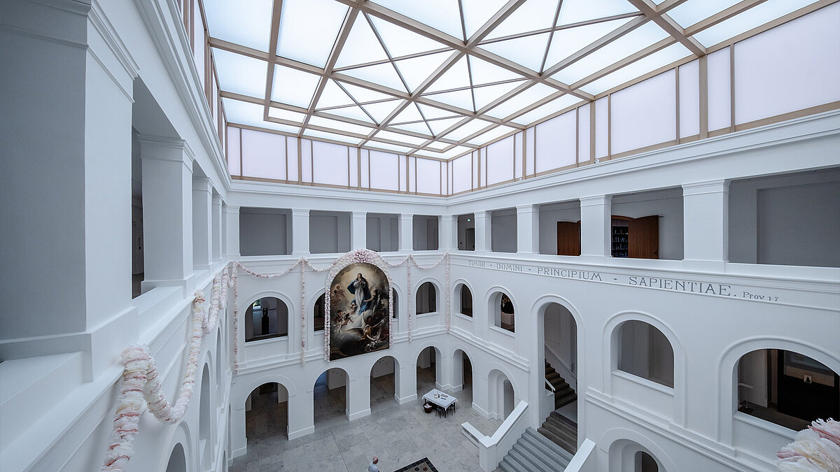 Blick in den hellen Innenraum mit architektonischen Bögen und Glasdach