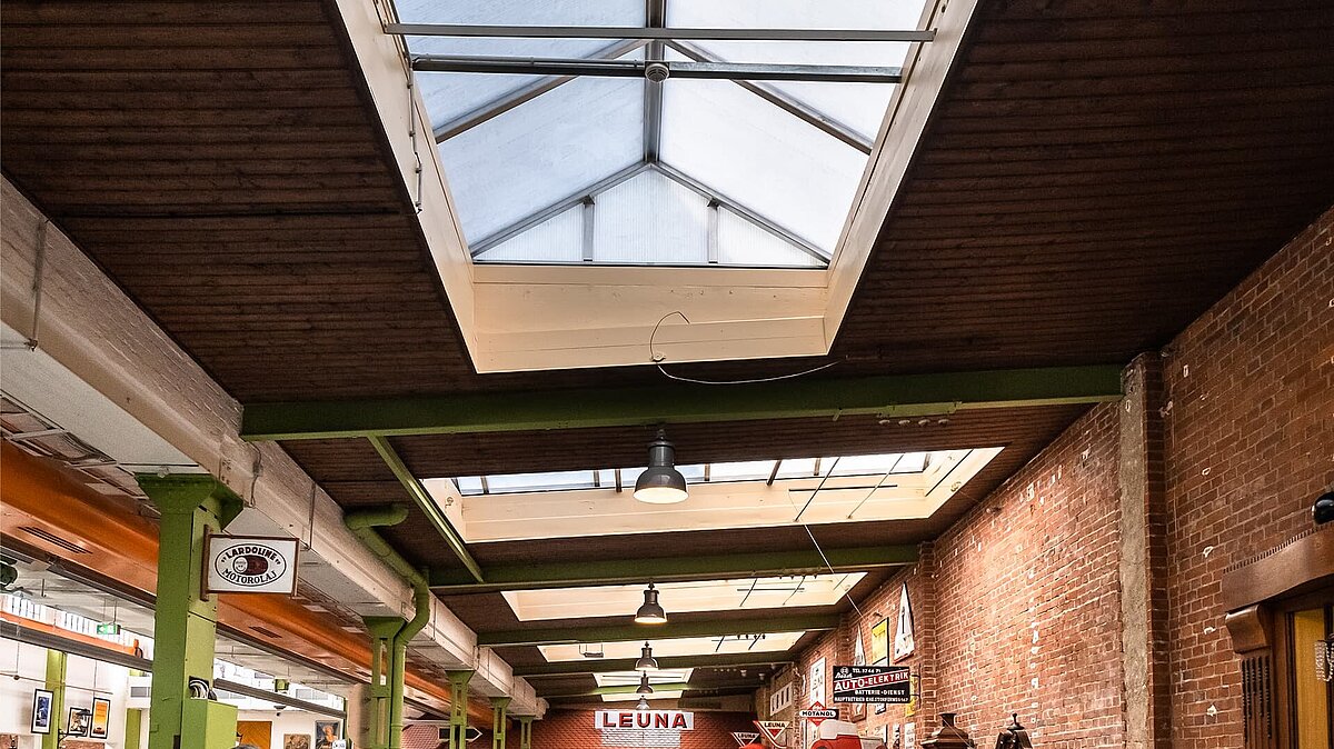 Innenansicht der Eventhalle Zündmagnet in Wurzen mit Glasdach, grünen Stahlträgern und Backsteinwänden im Industriecharme.