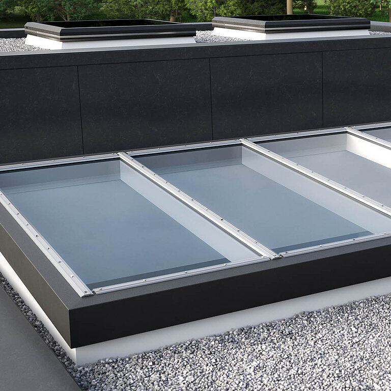 Nahaufnahme Glasdach Fire Resistance mit drei Feldern auf Flachdach mit Kiesumrandung.