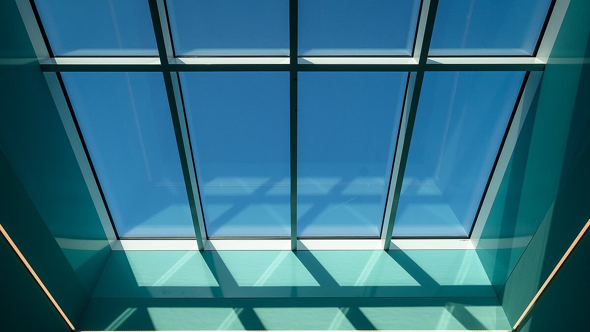 Innenraum des Kindergartens „World of Kids“ mit modernem LAMILUX Glasdach und farbenfroher Gestaltung.