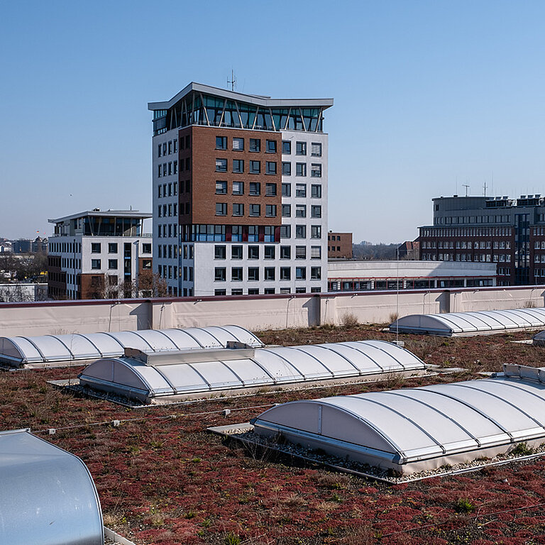 Mehrere LAMILUX Lichtbänder auf Flachdach eines urbanen Gebäudekomplexes zur Tageslichtversorgung