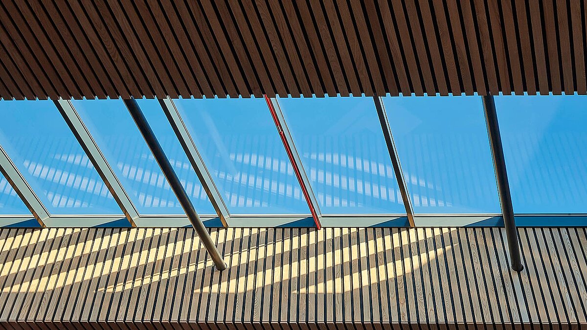 Innenansicht des LAMILUX Glasdachs PR60 an der Sheffield Hallam University mit Holzelementen und Schattenwurf.