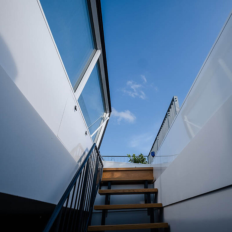 Innenansicht eines LAMILUX Flachdach Ausstieg Komfort Swing mit seitlich schwenkender Öffnung und Treppenaufgang für sicheren Dachzugang