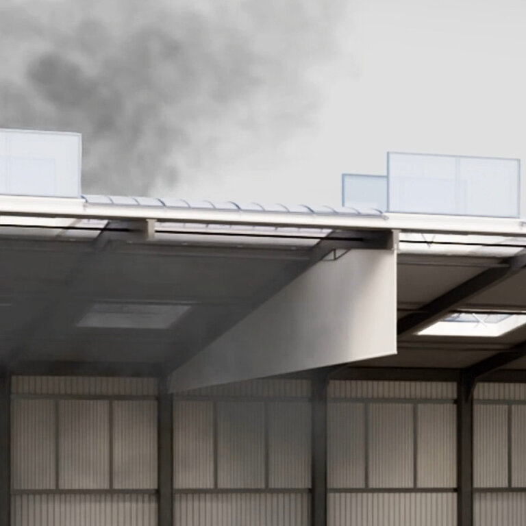 Dachbereich einer Industriehalle mit austretender Rauchentwicklung über der Dachkante und sichtbaren Dachaufbauten