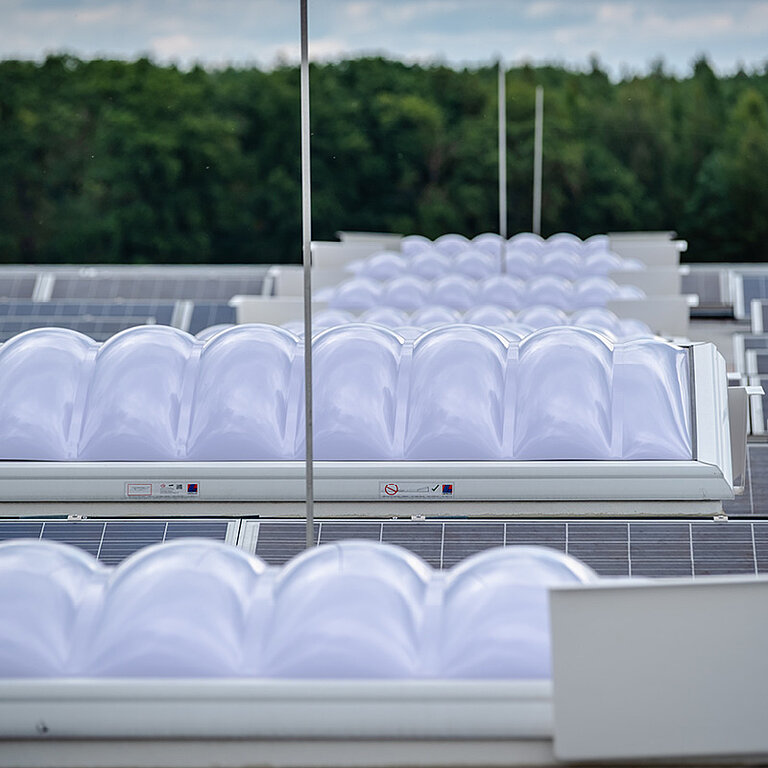 Mehrere LAMILUX Lichtkuppeln F100 W in Reihenmontage auf Flachdach zur großflächigen Tageslichtversorgung