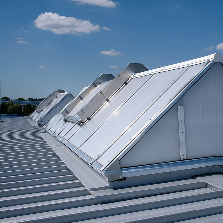 Mehrere geöffnete LAMILUX Lichtband S RWA auf Industrie-Flachdach mit Satteldachform