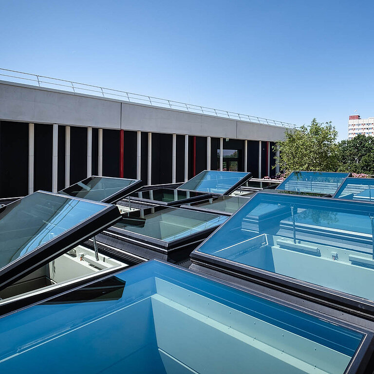 Mehrere LAMILUX Flachdach Fenster FE 3° auf Industrieflachdach, geöffnete Dachfenster für natürliche Lüftung und Tageslicht