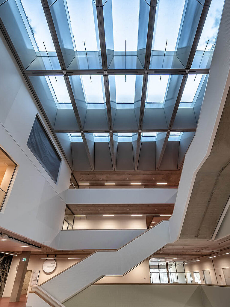 LAMILUX Flachdach Fenster FE 3° als Lichtband über Atrium, geneigte Verglasung für gleichmäßigen Tageslichteinfall