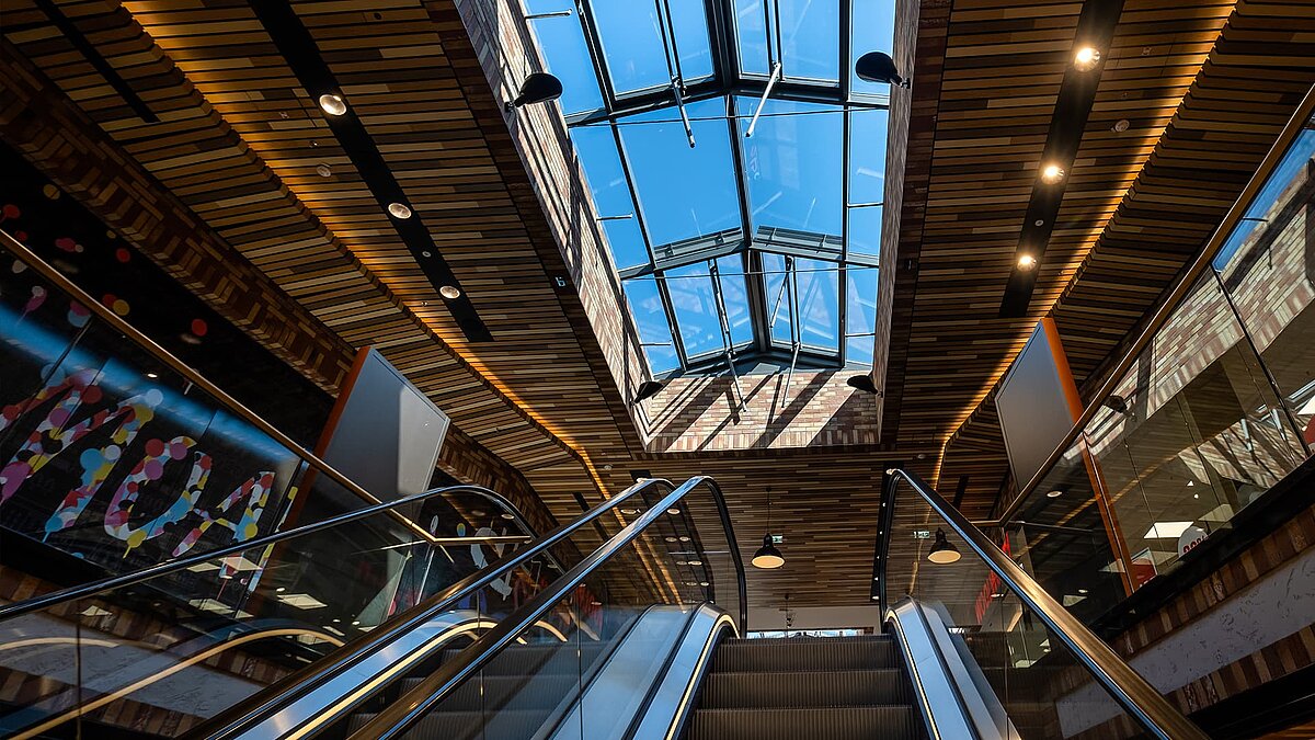 Glasdächer von LAMILUX im Schultheiss Quartier in Berlin-Moabit, Blick von unten auf das Dach über einer Rolltreppe.