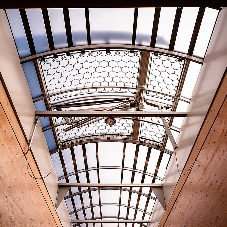 Innenansicht eines LAMILUX Lichtbands mit gebogener Verglasung und intensivem Tageslichteinfall