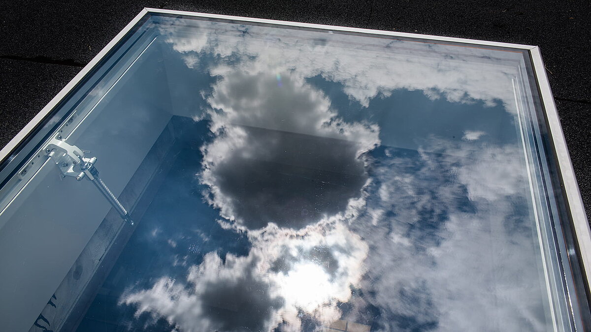 Reflektion von Wolken auf einem LAMILUX Flachdach Ausstieg eines Wohnhauses in Korneuburg.