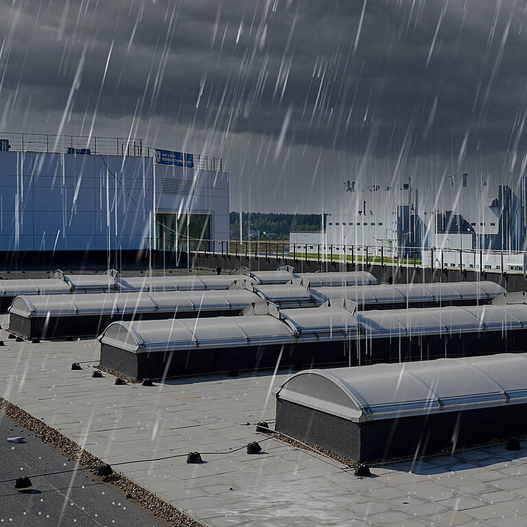 Mehrere LAMILUX Lichtbänder in Bogenform auf Flachdach bei Regen