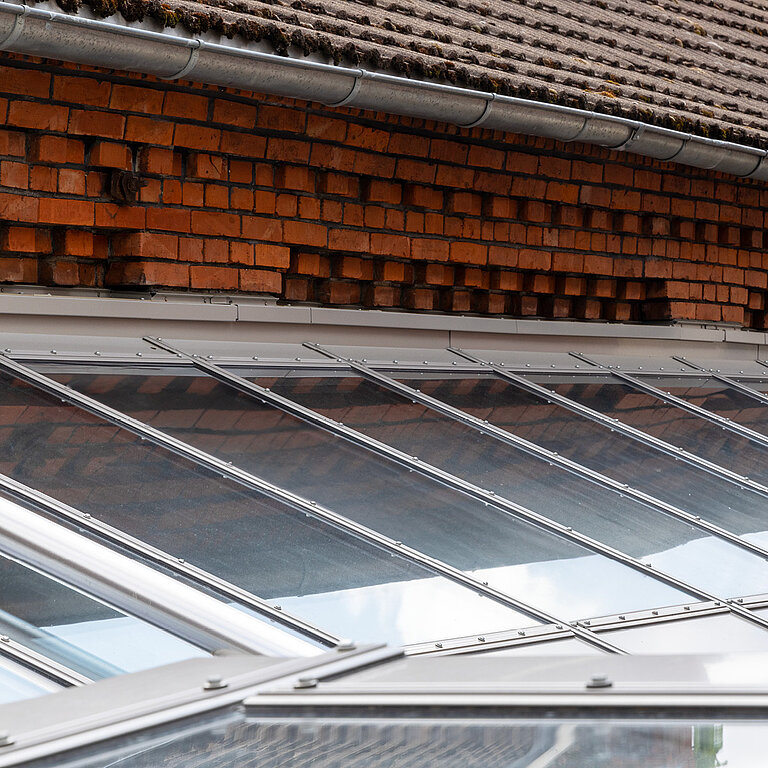 Glasdach Fire Resistance mit geneigter feuerbeständiger Verglasung und Ziegelhintergrund.