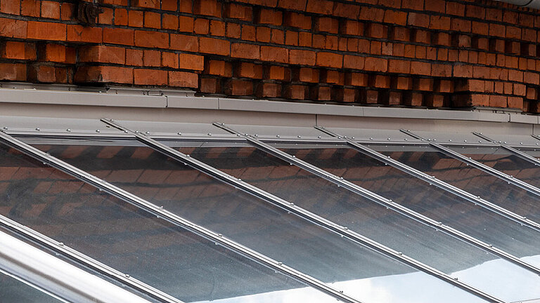 Glasdach Fire Resistance mit geneigter feuerbeständiger Verglasung und Ziegelhintergrund.