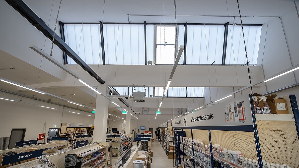 Modernisierter Innenbereich des alten Postbahnhofs Leipzig, jetzt genutzt als Fachmarkt mit Lichtbändern.