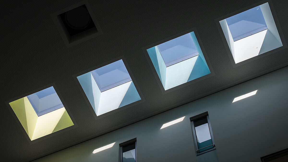 Blick vom Gebäudeinneren auf vier quadratische Flachdach Fenster