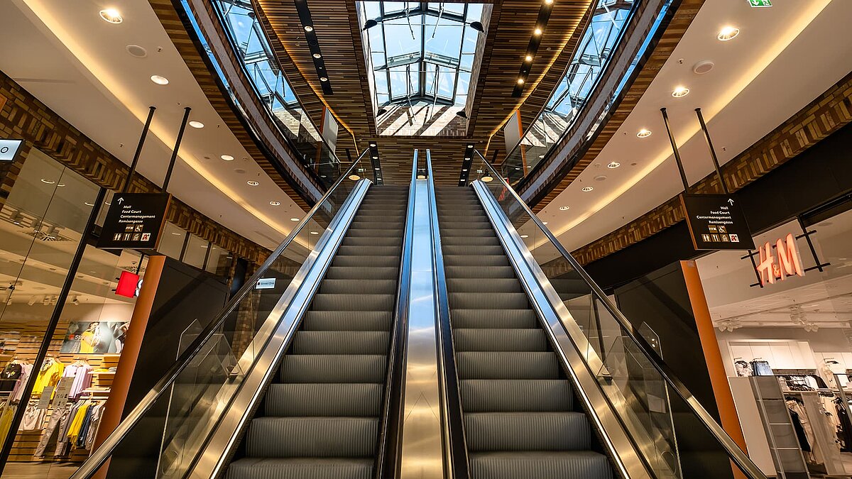 Rolltreppen im Schultheiss Quartier in Berlin-Moabit mit Blick auf die Glasdächer von LAMILUX.