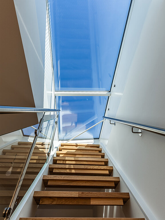 Moderne Holztreppe mit Glasgeländer unter einem Flachdach Ausstieg