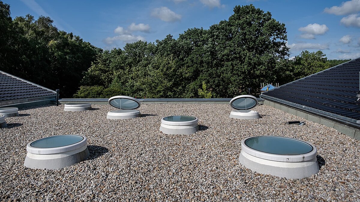 Runde Oberlichter auf dem Kies-Flachdach der Kita Sonnenfeld.
