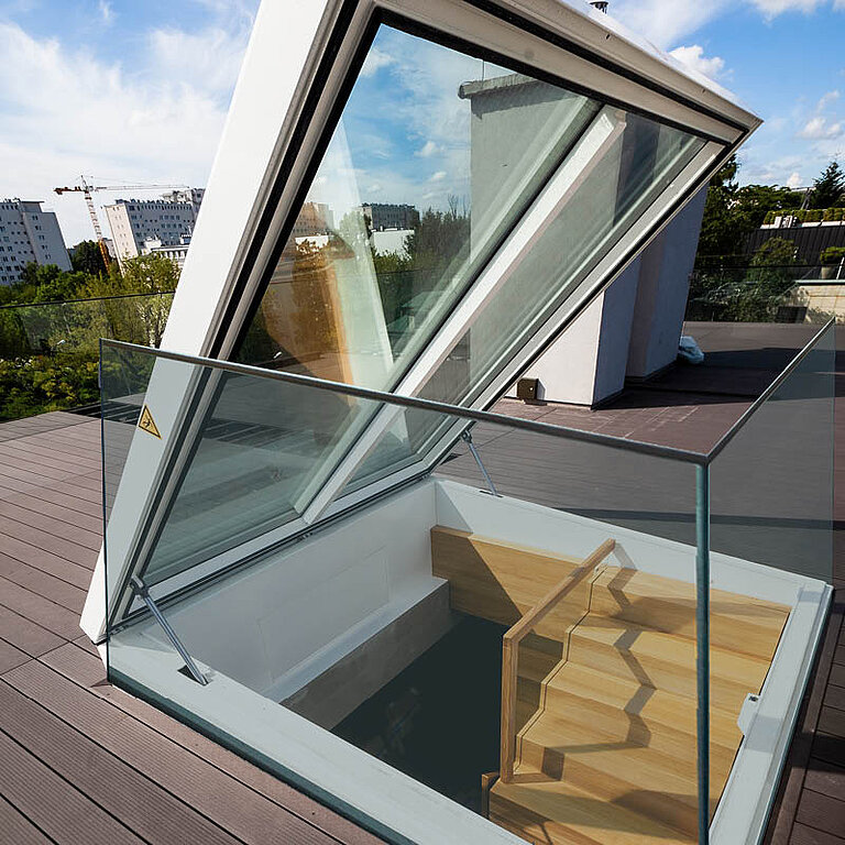 Geöffneter LAMILUX Flachdach Ausstieg Komfort Quadrat mit seitlicher Glasbrüstung und Holzstufen