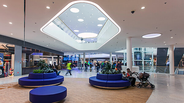 Blick auf Sitzmöglichkeiten in der Bory Mall mit Tageslicht Elementen über ihnen