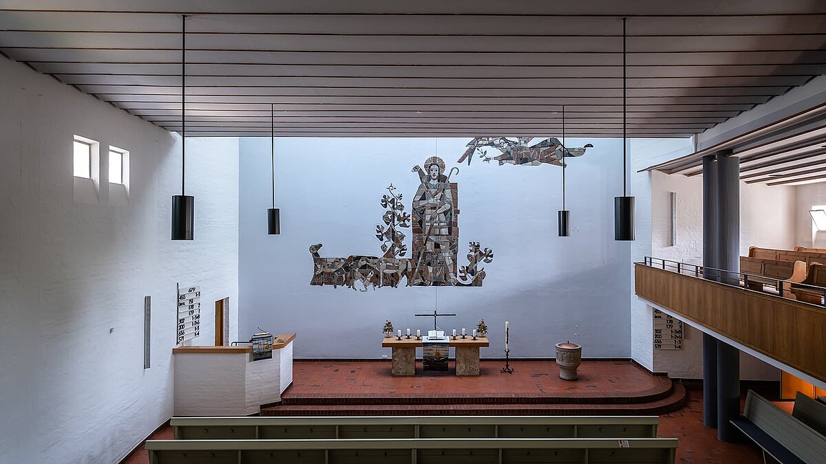 Innenraum der Pauluskirche in Traunreut mit LAMILUX Flachdachfenstern FE und großem Wandmosaik im Altarbereich.