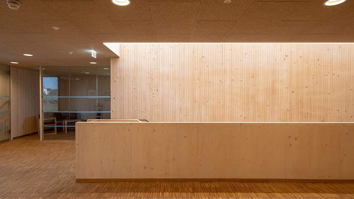 Innenbereich der Kinderkrippe Waltenhofen mit modernem Holzwanddesign und Glasabtrennung.