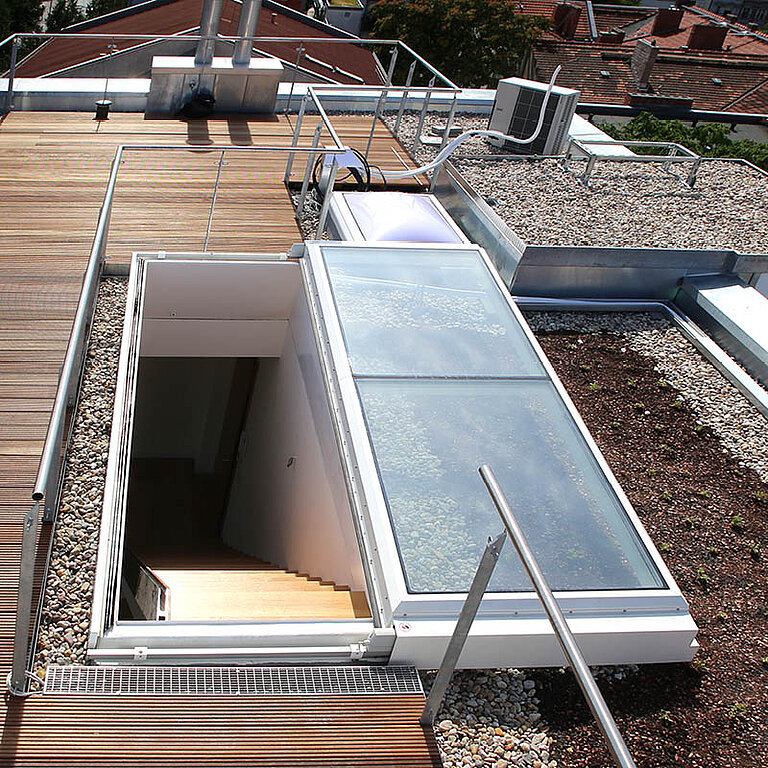 Geöffneter LAMILUX Flachdach Ausstieg Komfort Solo mit rechteckiger Öffnung, seitlichem Geländer und Treppenabgang
