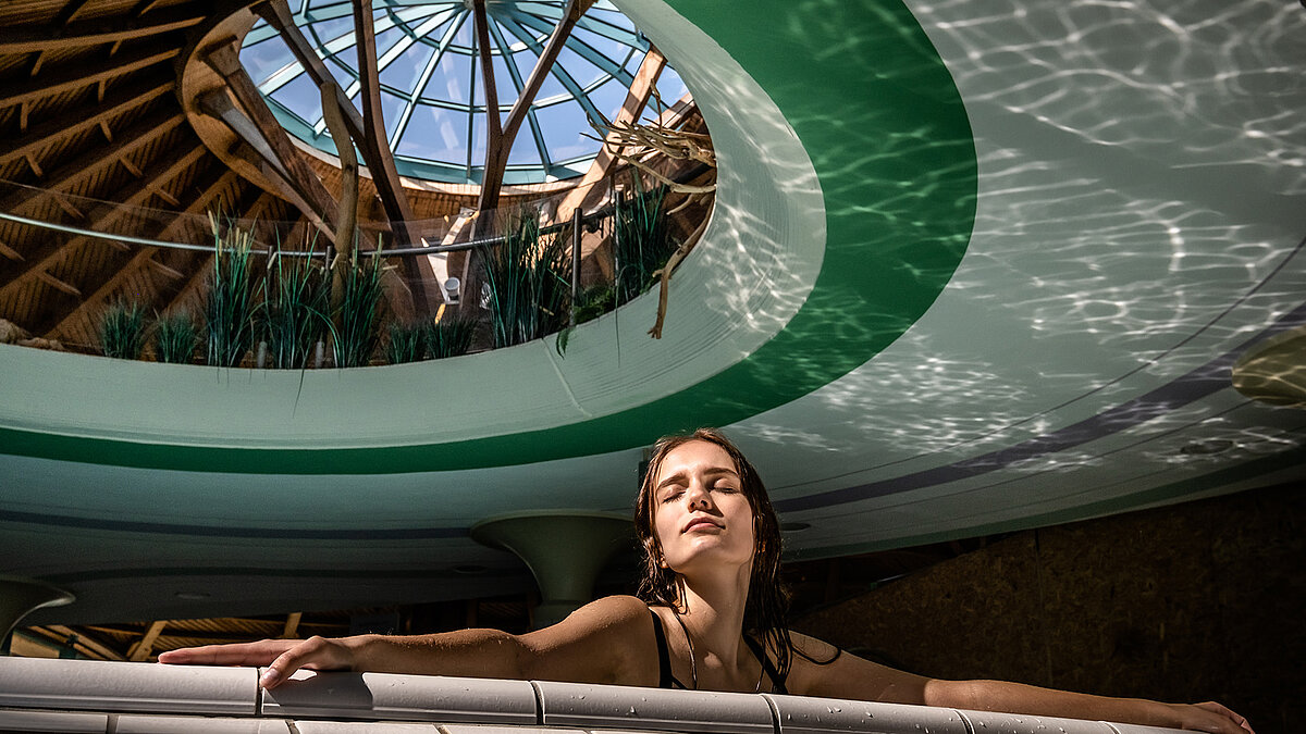 Frau entspannt sich im Wasser unter der Glaskuppel der Soletherme Solemar in Bad Dürrheim.