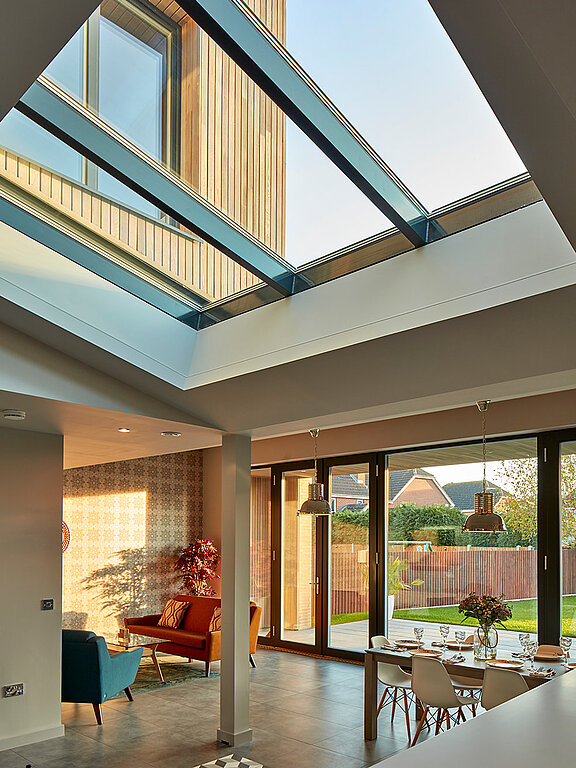 Innenraum der Potton Show Homes in England mit LAMILUX Glasdach PR60, das Tageslicht in den modernen Wohnbereich bringt.