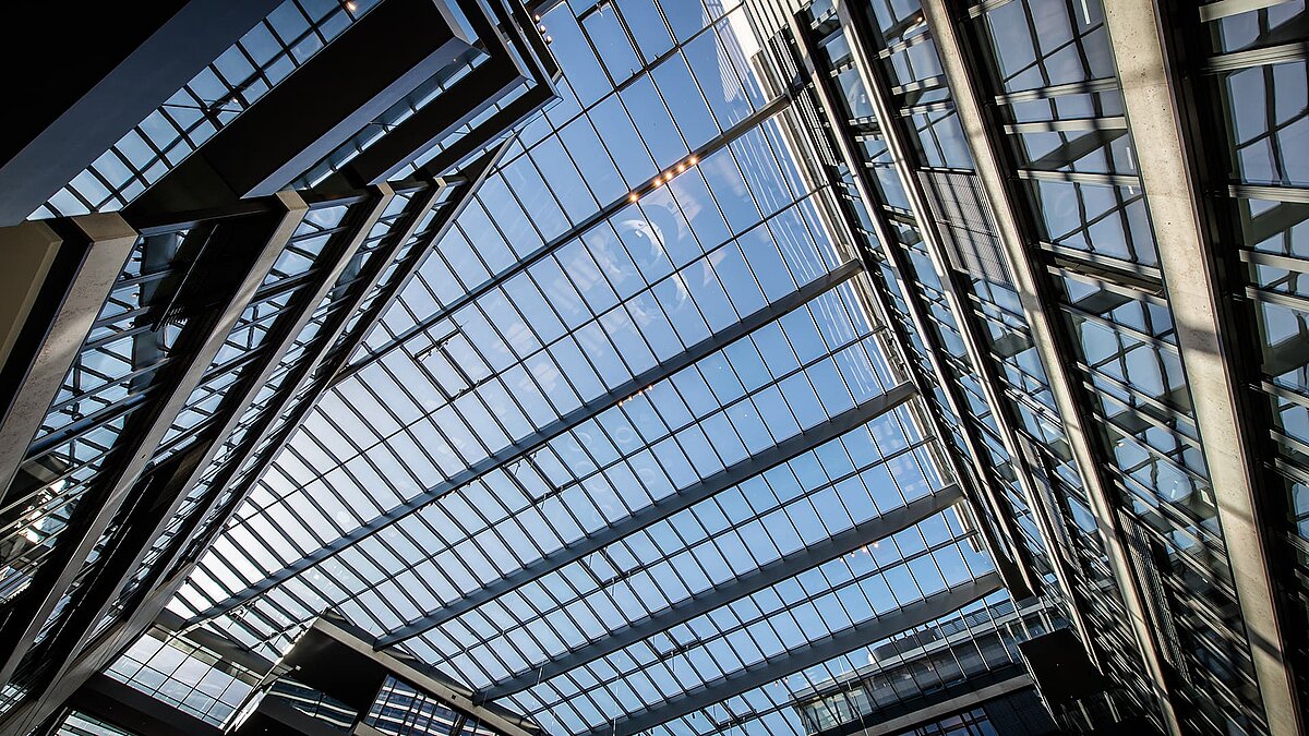 Modernes Glasdach des FGS Campus mit großen Glasflächen und klarer Spiegelung des Himmel.