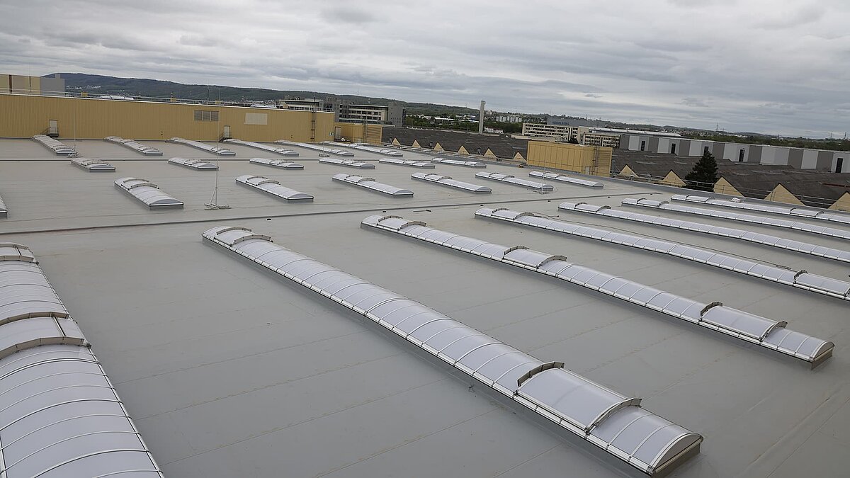 Dach der Heidelberger Druckmaschinen mit zahlreichen gebogenen Lichtbändern zur natürlichen Tageslichtbeleuchtung.