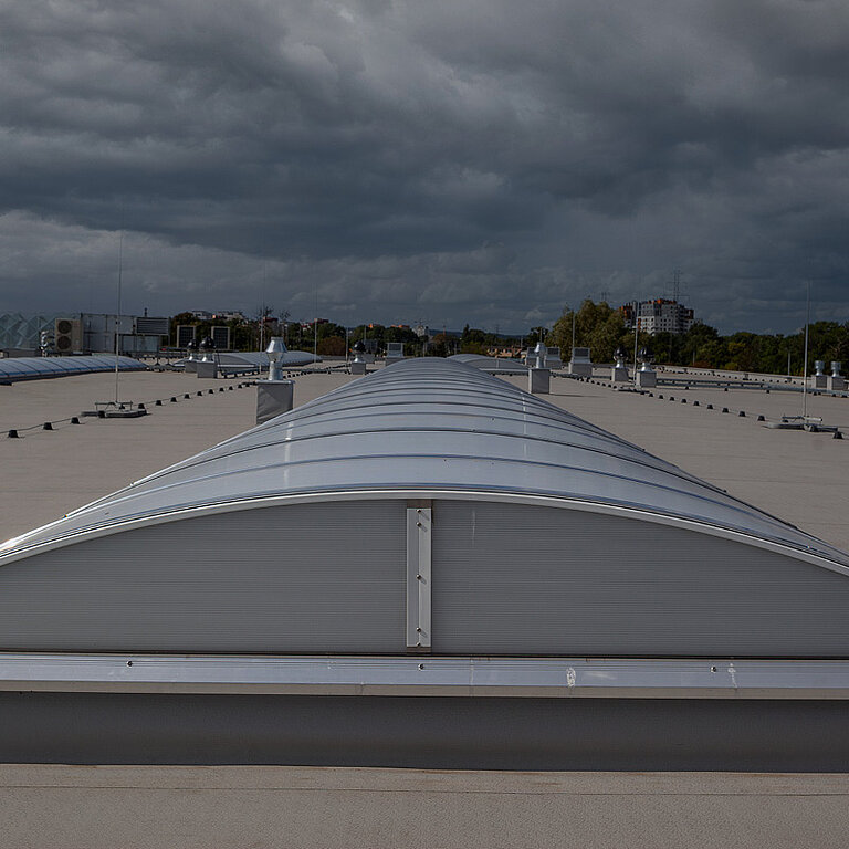 LAMILUX Lichtband B Passivhaus auf großem Flachdach mit bogenförmiger Verglasung