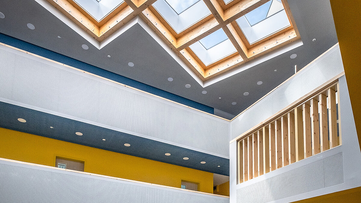 Helles Atrium mit Holzrahmen und LAMILUX Flachdach Fenstern