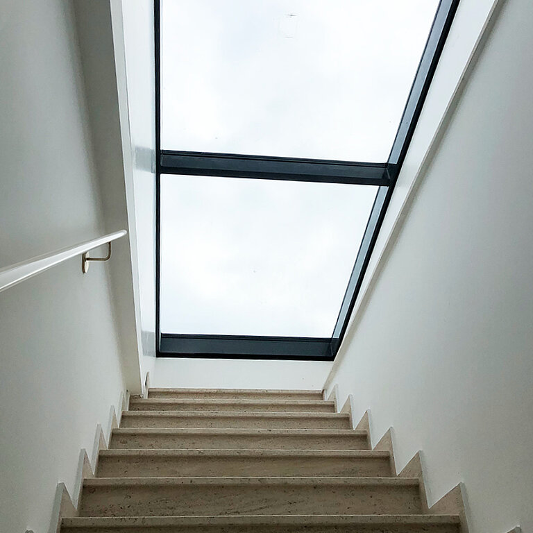 Innenansicht eines LAMILUX Flachdach Ausstieg Komfort Solo mit geöffneter Verglasung und Treppenaufgang für direkten und sicheren Dachzugang