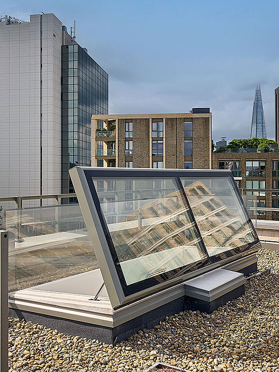 LAMILUX Flachdach Ausstieg auf dem Dach der Mulberry Academy London, umgeben von Kiesbelag und moderner Architektur