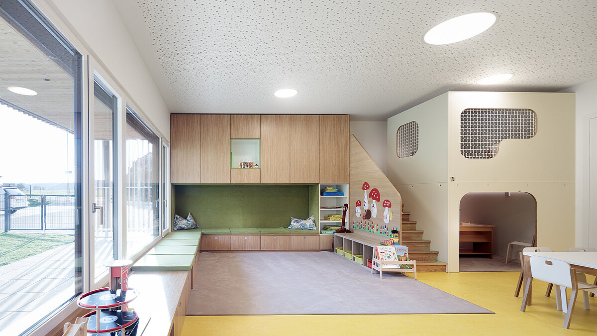 Blick in ein Zimmer der Kindertagesstätte mit einer Turnmatte und Licht dank Tageslichtelement