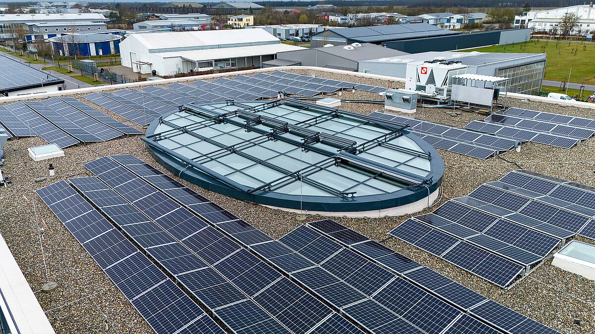 Flachdach des Kompetenzzentrums Breisgau mit Solarpaneelen und großem ovalem Glasdach in der Mitte