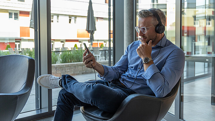 Mann hört einen Podcast übers Handy