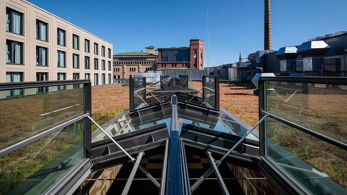 LAMILUX Glasdach PR60 im Schultheiss Quartier mit geöffneten Lüftungselementen auf Gründach.