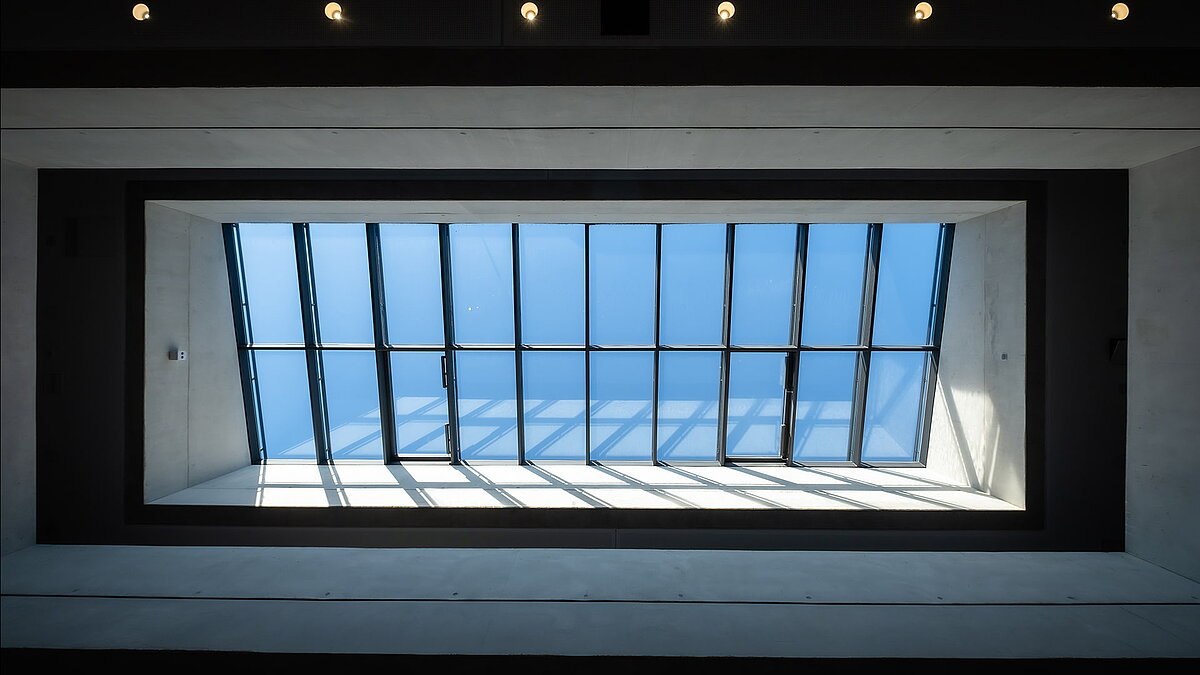 Oberlichter in der Bertha-von-Suttner-Realschule Köln, die natürliches Tageslicht durch eine moderne Glasdachkonstruktion hereinlassen.