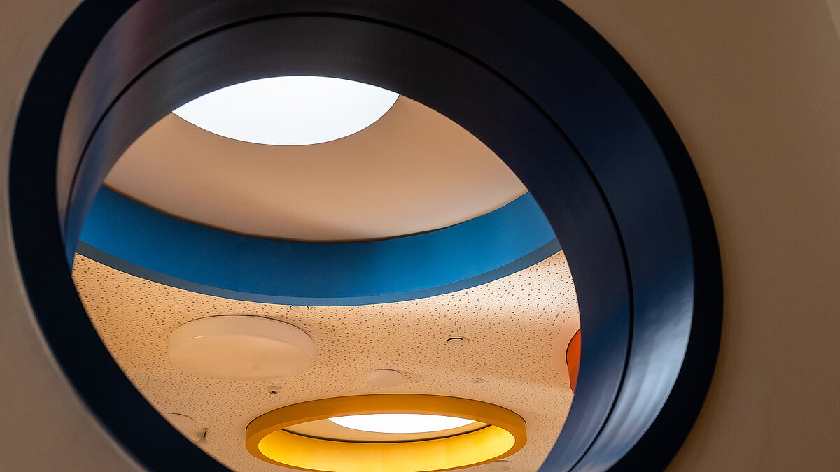 Innenansicht der Kindertagesstätte Glückliche Zukunft in Sömmerda mit runden, farbenfrohen Deckenöffnungen und Oberlichtern.