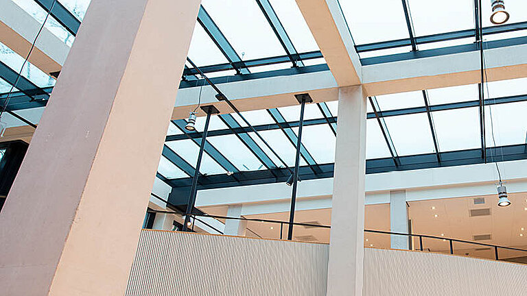 Innenansicht eines Atriums mit Glasdach PR60 Passivhaus und modernen Designelementen.