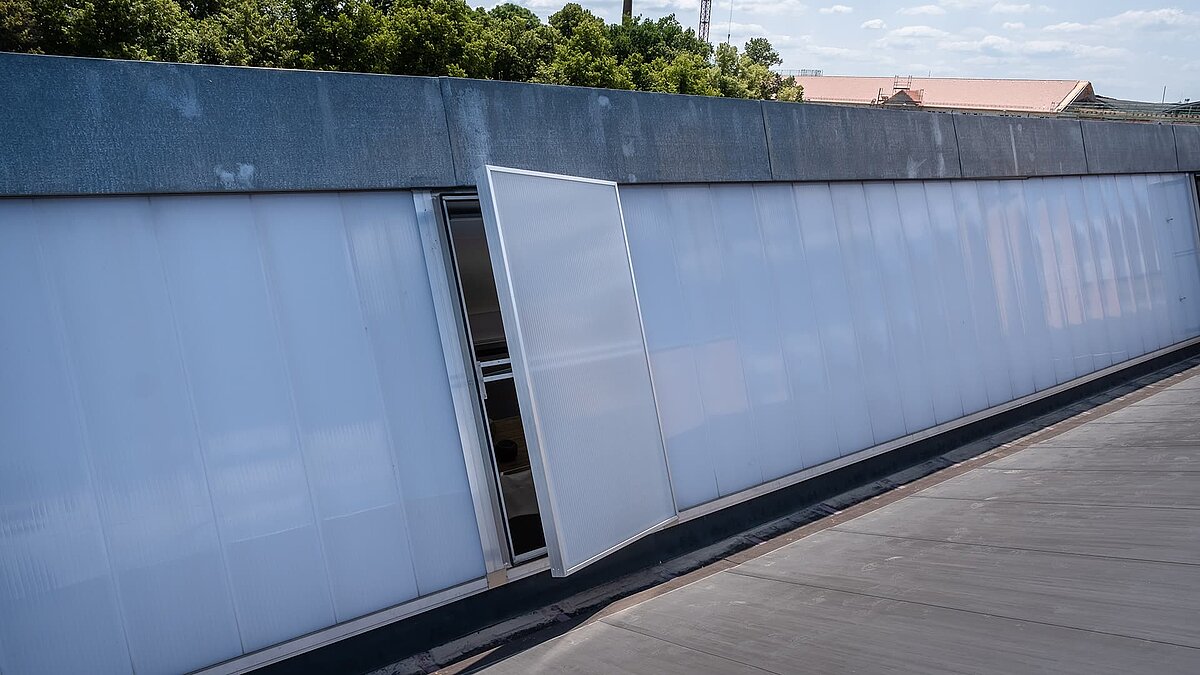 Detailansicht des Dachs des alten Postbahnhofs Leipzig mit modernen Lichtband W/R und geöffnetem Lüftungselement.