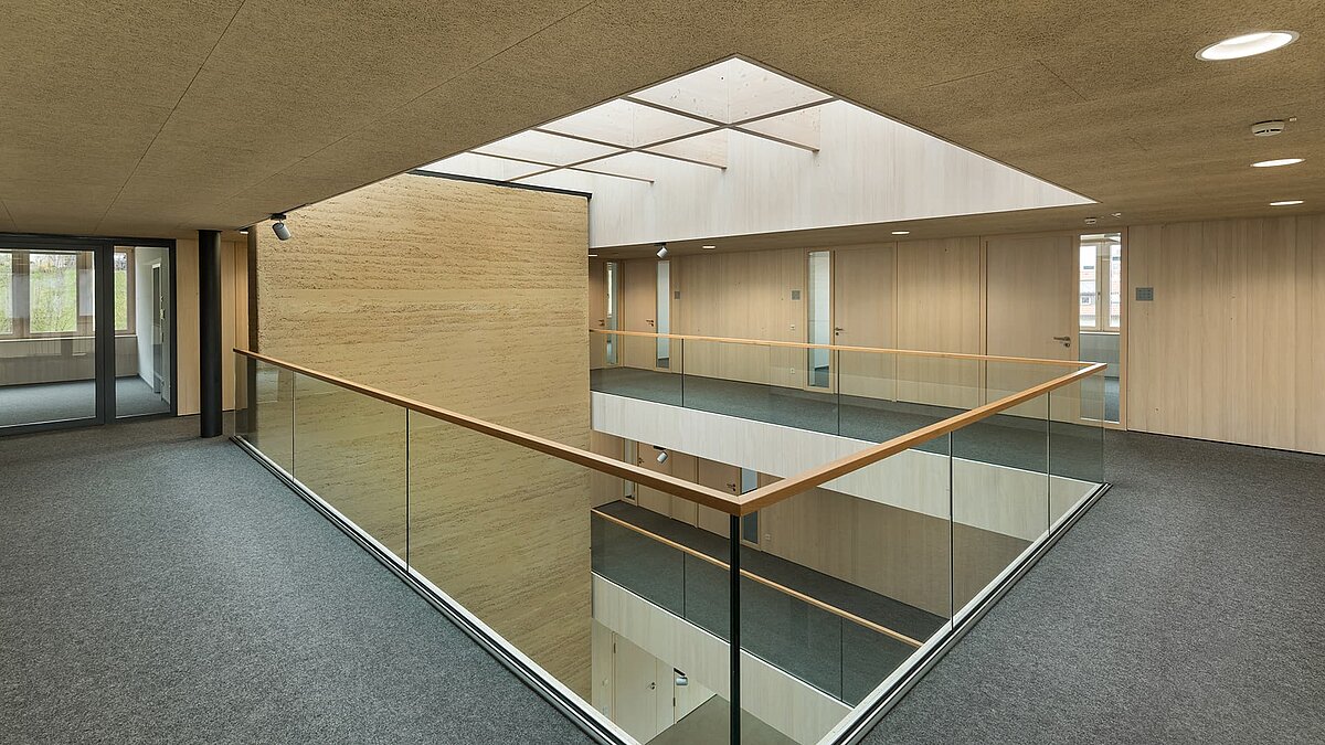 Modernes Innenraumdesign mit Glasgeländer und Glasdach im Grünen Zentrum Immenstadt.