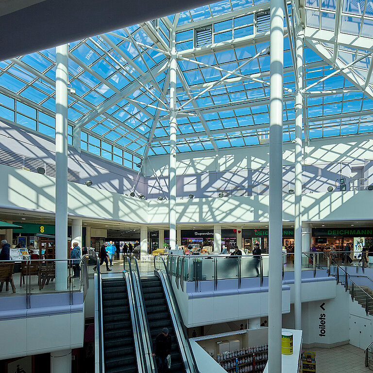 Einkaufszentrum mit großflächigem Glasdach PR60 und filigraner Stahlkonstruktion.