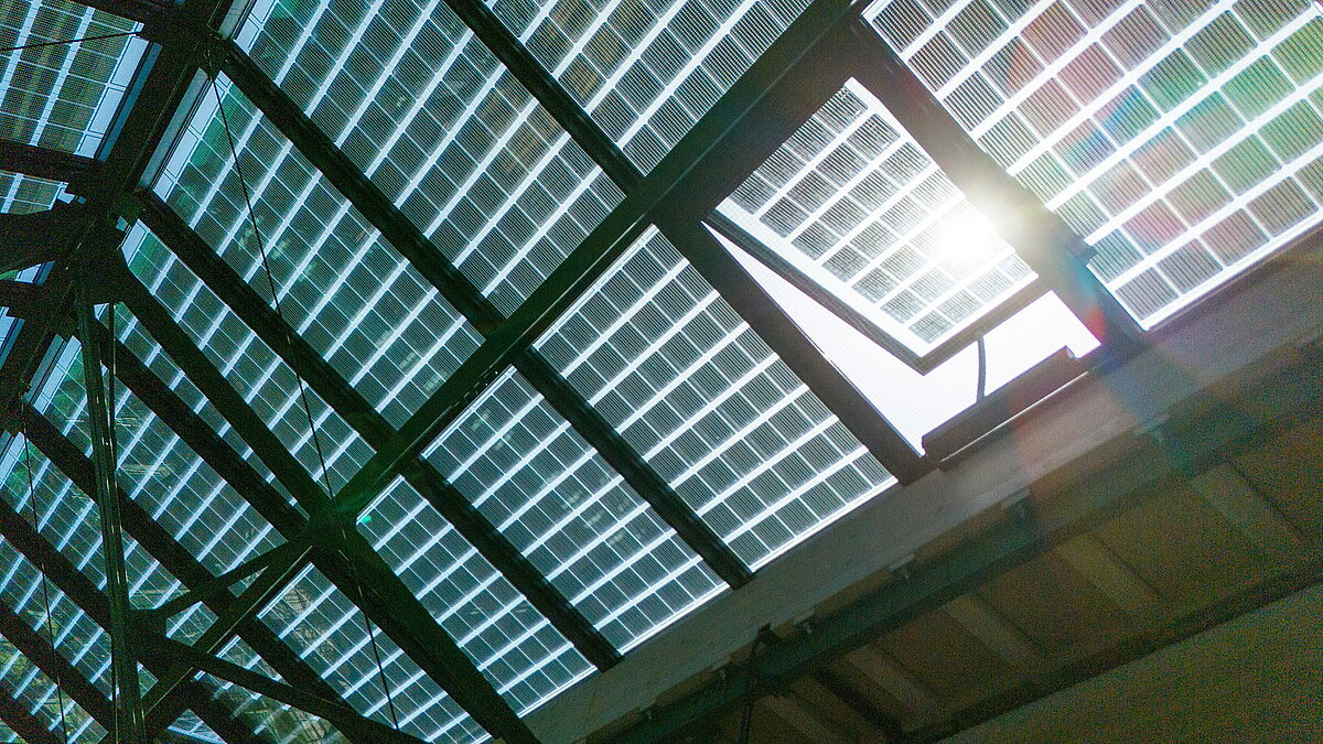 Detailansicht eines geöffneten Lüftungselements im LAMILUX Glasdach PR60 mit integrierten PV-Modulen.