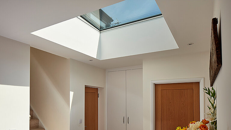Flachdach Fenster bringt Licht in einen Flur mit Treppe und zwei Türen
